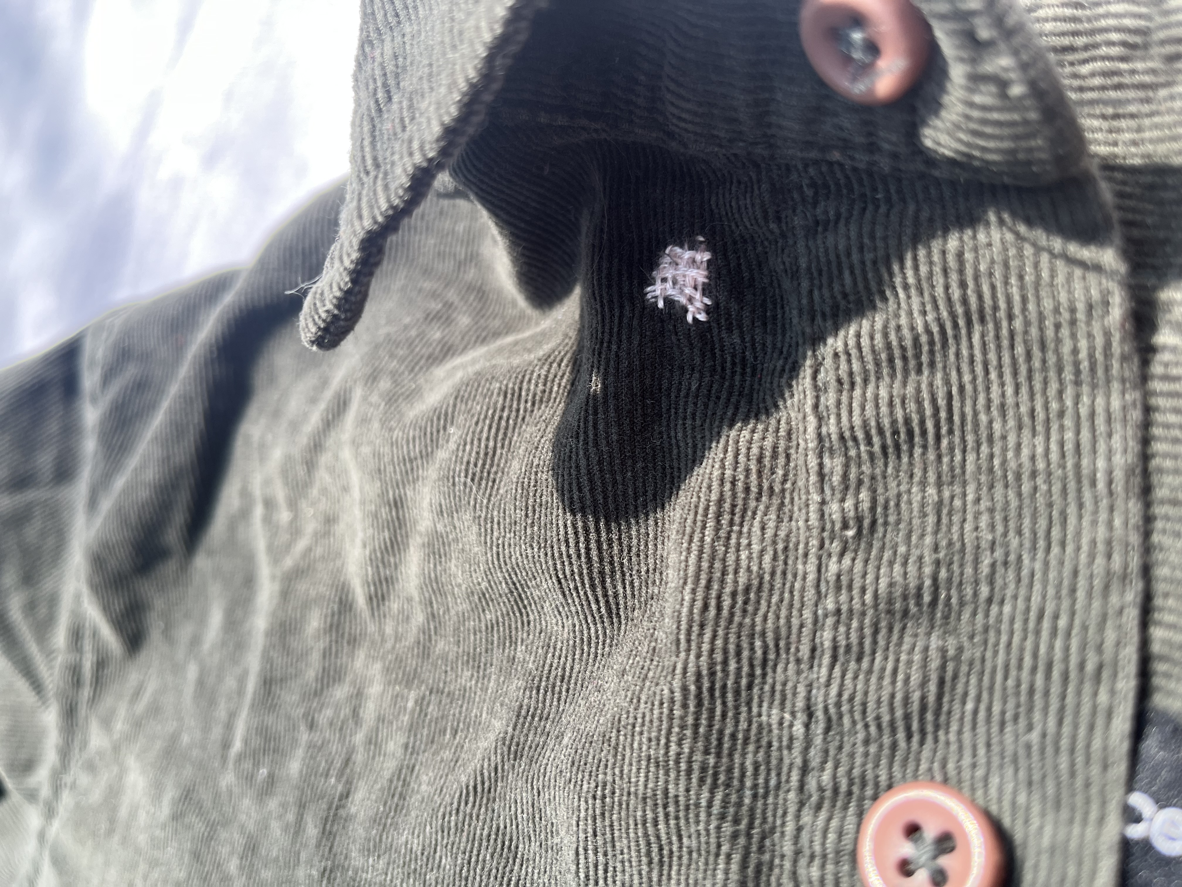 close up of shirt with a colourful darn over a small tear